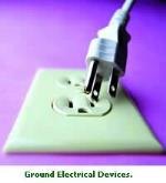 Plug hanging out of three-pronged electrical socket with purple background